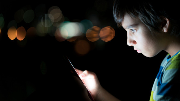 Child's face illuminated by a digital screen