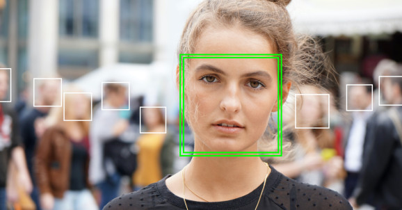 young woman picked out by face detection or facial recognition software - several other faces detected in crowd of people in background (young woman picked out by face detection or facial recognition software - several other faces detected in crowd of