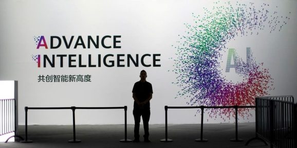 A security officer keeps watch in front of an AI (Artificial Intelligence) sign at the annual Huawei Connect event in Shanghai, China.