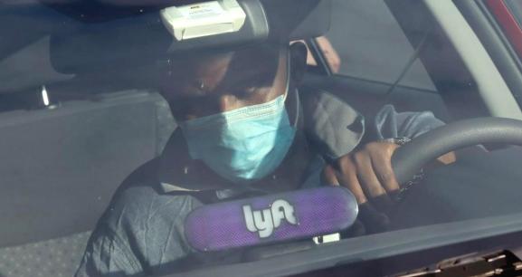 A Lyft driver wears a mask during the coronavirus outbreak, as he leaves passengers in the U.S. Capitol Hill neighborhood in Washington, U.S. April 1, 2020.