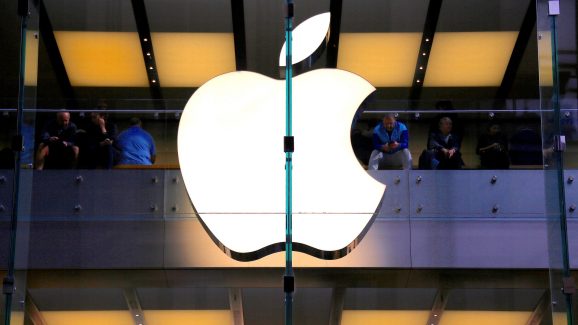 A customer stands underneath an illuminated Apple logo as he looks out the window of the Apple store located in central Sydney, Australia, May 28, 2018.
