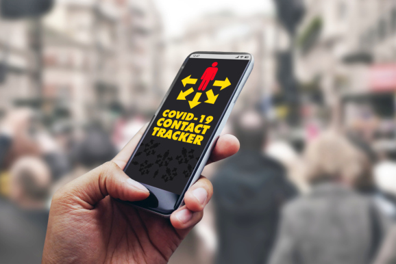 hand holding a smartphone with a contact tracing app loaded, on busy sidewalk