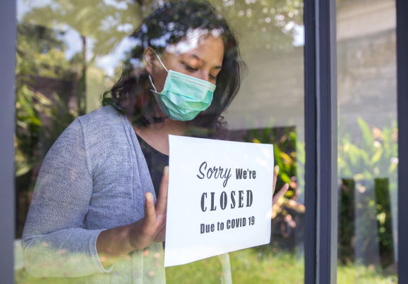 business owner puts up a closed sign in window
