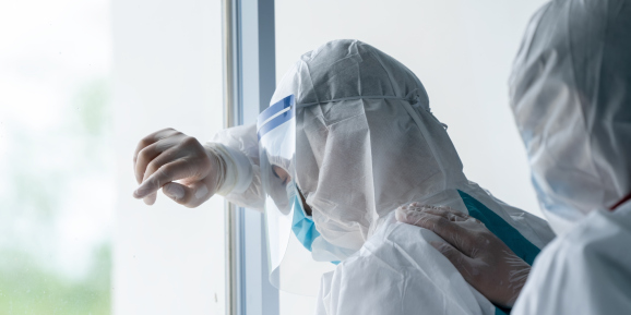 Exhausted doctor wearing protective suit to fight COVID-19