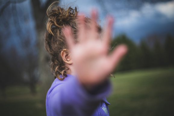Girl blocks camera with her hand