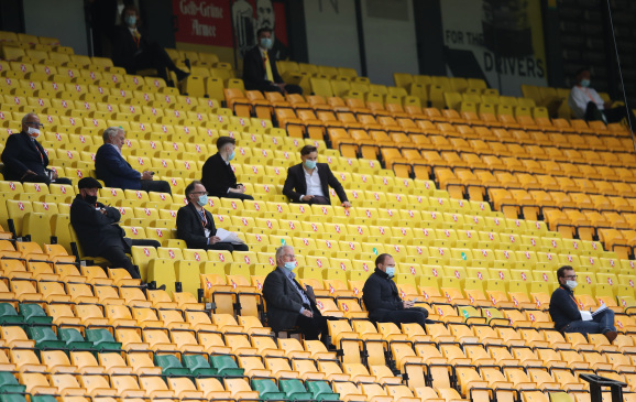 NORWICH, ENGLAND - JULY 11: People look on from the stands whilst social distancing during the Premier League match between Norwich City and West Ham United at Carrow Road on July 11, 2020 in Norwich, England. Football Stadiums around Europe remain empty due to the Coronavirus Pandemic as Government social distancing laws prohibit fans inside venues resulting in all fixtures being played behind closed doors. (Photo by Alex Pantling/Getty Images)