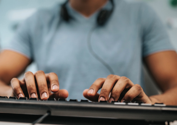 Close up of black programmer using computer keyboard.