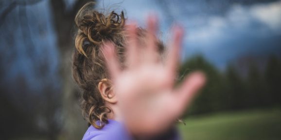 Girl blocks camera with her hand