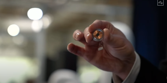 Elon Musk holding a Neuralink link device